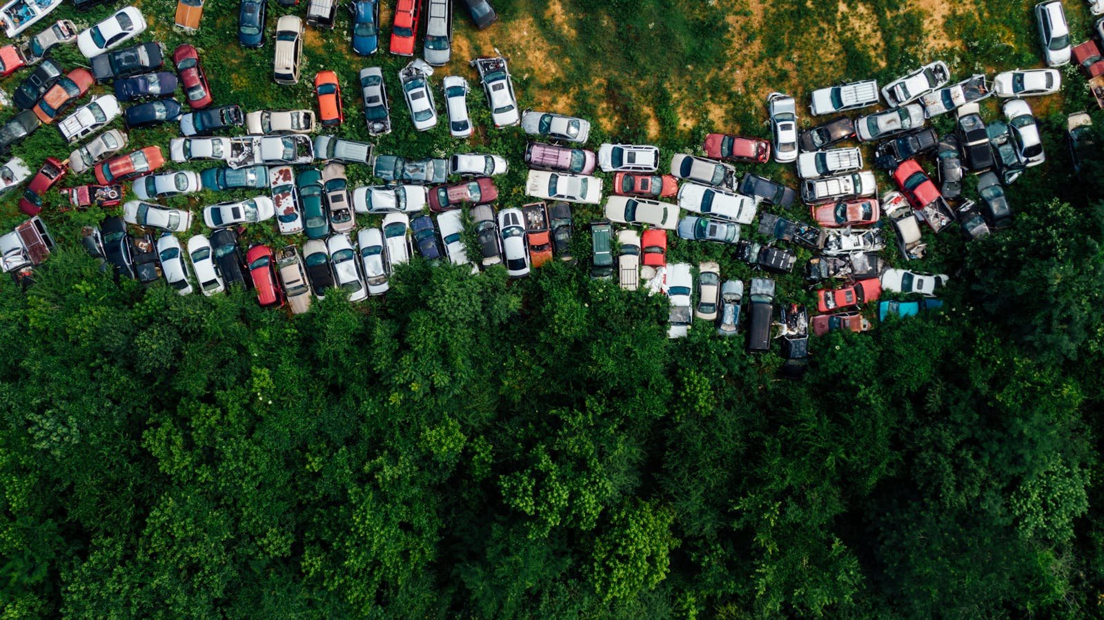 Contactar Dispersiones Mendoza Viladecans - Aerial shot of a junkyard with abandoned cars surrounded by greenery.